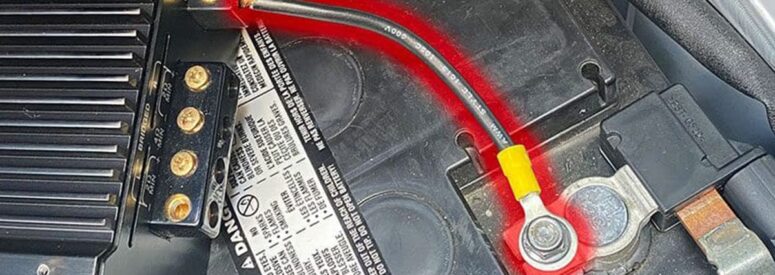 A car audio amplifier attached to a battery