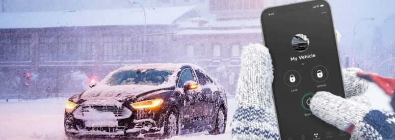 A person's hands pressing the start button for a remote start on their phone for their car which is covered in snow on a cold day