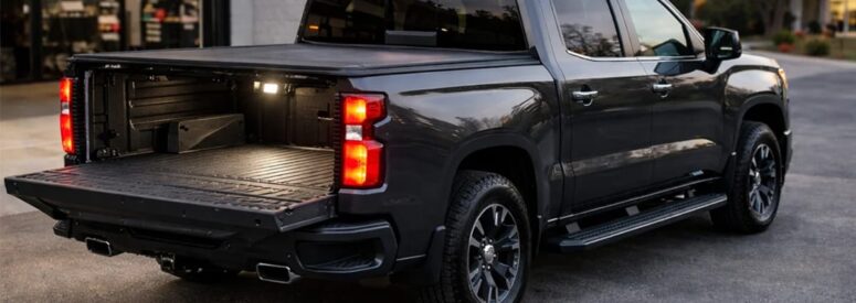 A black truck with a bed cover and its tailgate down